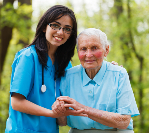Kind nurse together with elderly woman in the hospital's garden.